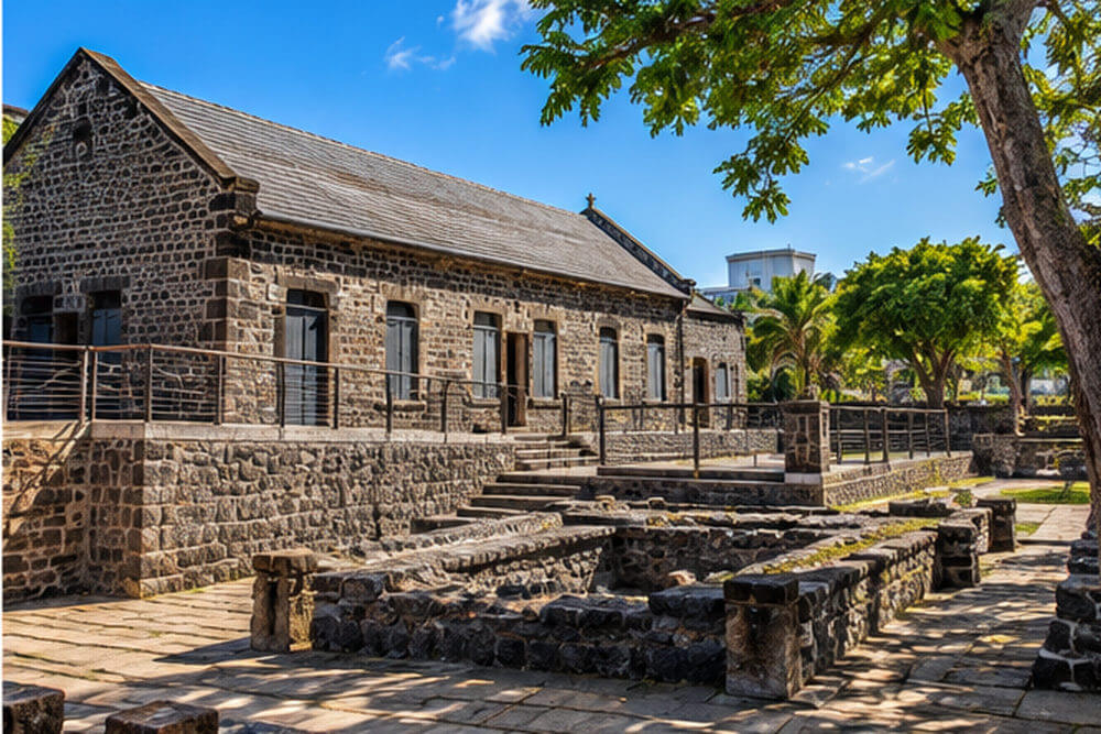 Kamienne mury i drewniane pomosty dawnego Aapravasi Ghat w Port Louis
