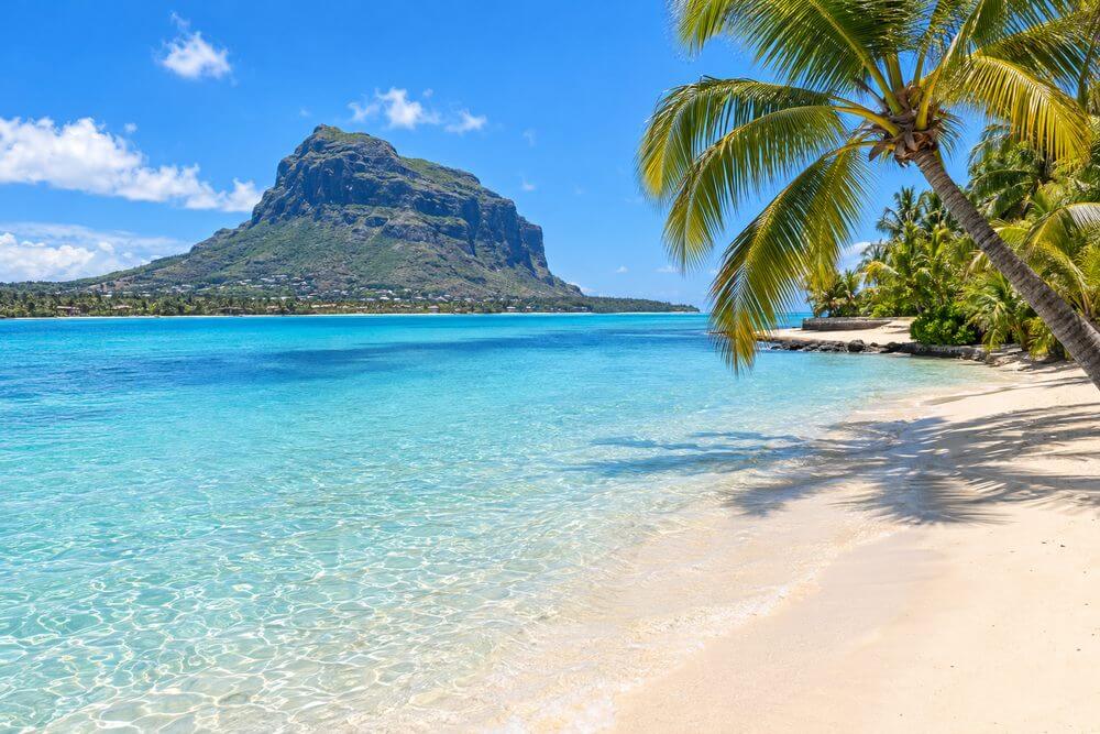 Spokojna laguna i piaszczysta plaża z widokiem na Le Morne na Mauritiusie